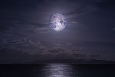Full moon over the sea. Elements of this image furnished by NASAの写真素材