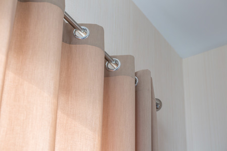 view diagonal of Cream colored curtains In steel rail close up viewの写真素材
