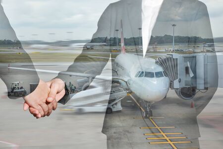 Double exposure of business women handshake and airport on motion background as partnership and transportation concept.の写真素材