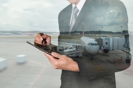 Double exposure of business man hand use tablet and airport as Communication and Transportation concept.の写真素材