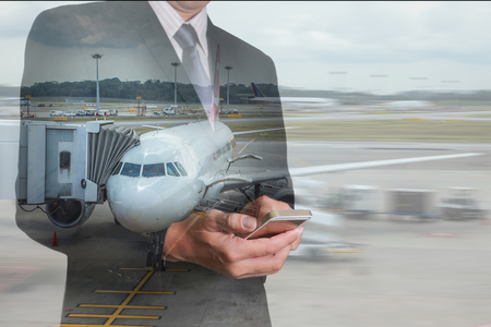 Double exposure of business man hand touch screen smart phone, mobile and airport on motion background as Communication and Transportation concept.の写真素材