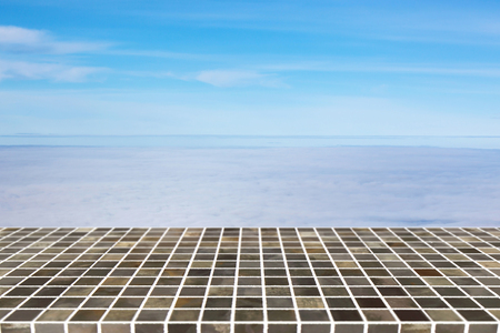 Square tile top on background of blurred clouds and  blue sky on above - can used for display or montage your productsの写真素材