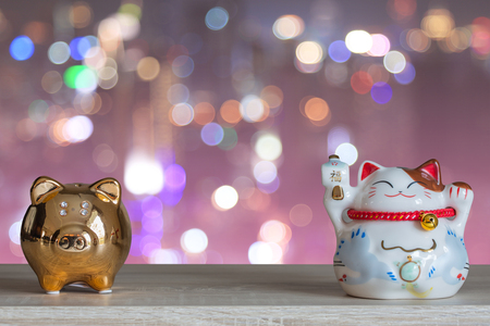 Lucky cat piggy bank on pink bokeh background, abstract background to time to start to saving or lucky for keep money concept.の写真素材