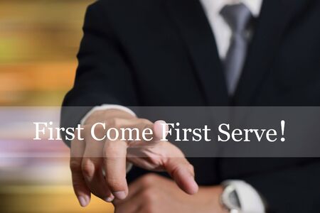 Businessman hand touching First Come First Serve sign on virtual screenの写真素材