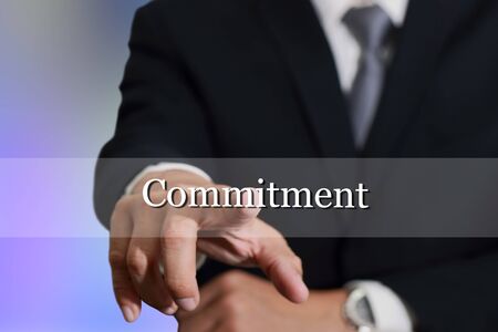 Businessman hand touching commitment sign on virtual screen as Commitment concept.の写真素材