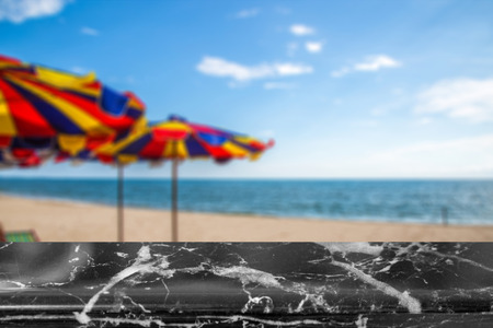 Natural marble black and white top on blurred abstract beach under blue sky background - can used for display or montage your products or your business.の写真素材
