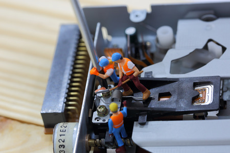 Selective focus of miniature engineer and worker fixed and repair cd rom of computer and use for...