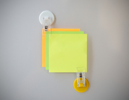 notes clip by white clip magnet on gray refrigerator background for input text.の写真素材