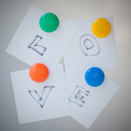 Colorful of Magnet paper clip text is love on gray refrigerator background, abstract background.の写真素材