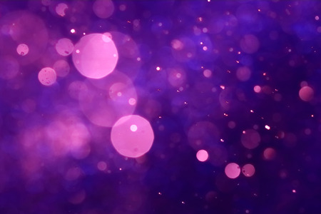 Pink bokeh on purple abstract background caused by spray water.の写真素材