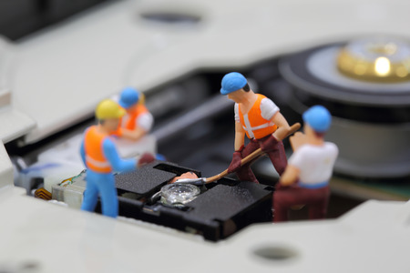 Selective focus of miniature engineer and worker fixed to clean CD rom reader of mainboard computer and use for business background.の写真素材
