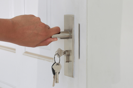 Hand hold door knob and open the white door as locksmith concept.の写真素材