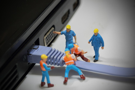 Selective focus of miniature engineer and worker install Lan cable to computer and use for business...