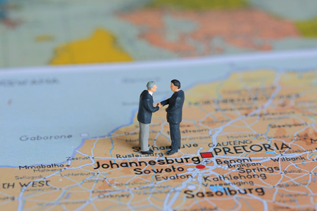 Selective focus of miniature businessman handshake and Johannesburg background as commitment and travel Conceptの写真素材