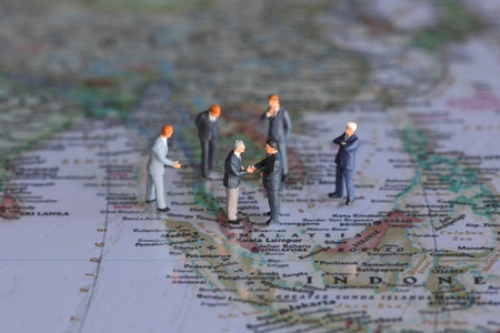 Selective focus of miniature businessman handshake on Malaysia world map background as commitment, agreement and partnership Conceptの写真素材