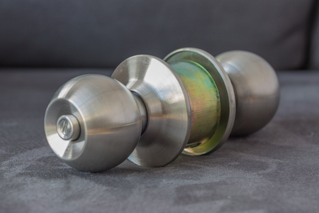 Stainless steel round ball door knob on dark gray suede as Locksmith concept.