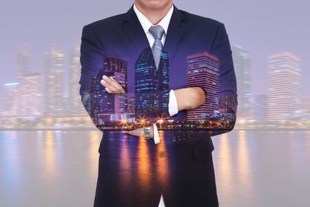 Double exposure of business man arms crossed, urban, city and lake at night as vision of leader concept.の写真素材