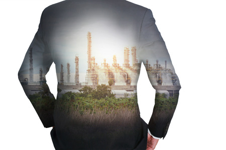 Double exposure of business man Back, looking ahead, Energy Generating Factory and sunset as Energy and Technology concept.の写真素材