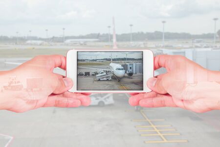 double exposure of man use two hand hold smart phone, tablet,cellphone and airplane as travel, transportation, communication and technology concept.の写真素材