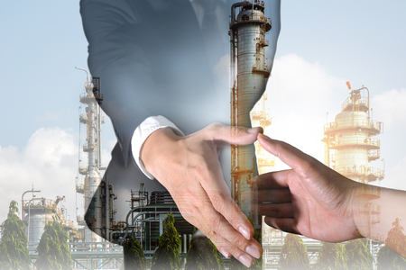 Businessman will handshaking for business relationship, Energy oil refinery Factory and sunset as Energy, Technology, Commitment and Partnership concept.の写真素材