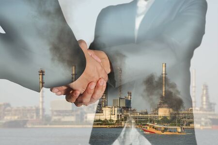 Double exposure of business women double handshake and oil refinery industry plant at daytime as business of energy concept.の写真素材