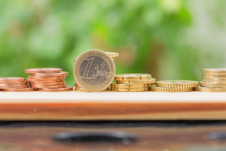 One euro and coins stacks on wooden isolated blur nature backgroundの写真素材