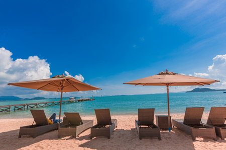 Chaise longue on the beach under blue sky and clouds as travel and relax conceptの写真素材