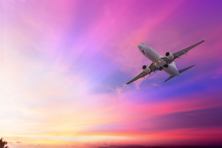 Airplane flying on the sky with sunset at twilightの写真素材
