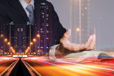 Double exposure of businessman hand hold, light trails on the street and urban in the night as business control concept.の写真素材