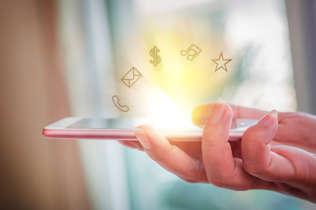 Hand hold smartphone with multimedia icon, mixed media as technology and innovation concept.の写真素材