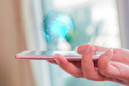 Smartphone and light blue circular world map with mesh line networking as globalization, technology and innovation conceptの写真素材