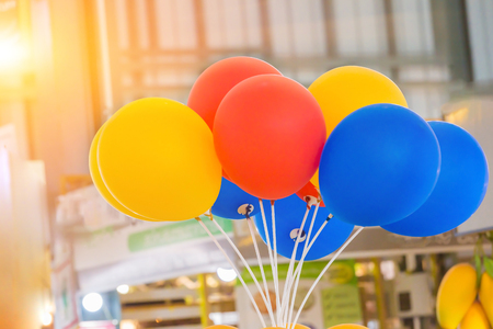 blue, yellow and orange balloon with sunlight of sunset backgroundの写真素材