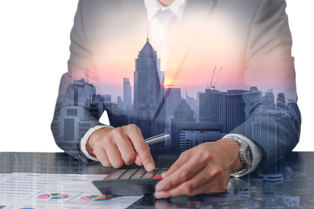 Double exposure of businessman working with calculator, cityscape and urban at sunset as business, worker, communication and Calculation conceptの写真素材