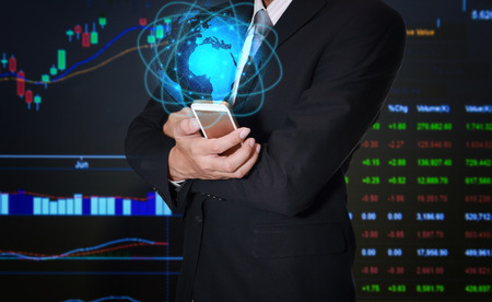 Businessman use smartphone or mobile for trading the stock as business, technology, communication, investment, gamble and rich concept.の写真素材