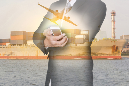 Double exposure of businessman hand hold smartphone, container cargo ship, cargo plane and airplane at sunset as business, technology, industrial, transportation, logistic and import export conceptの写真素材