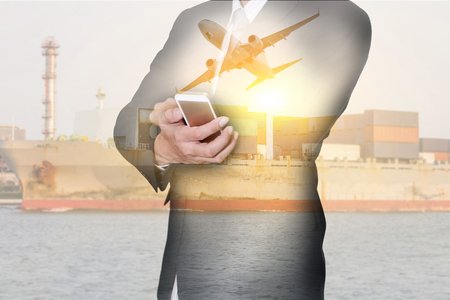 Double exposure of businessman hand hold smartphone, container cargo ship, cargo plane and airplane at sunset as business, communication, industrial, transportation, logistic and import export conceptの写真素材