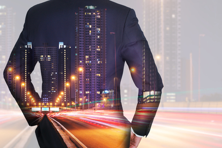 Double exposure of businessman Back, looking ahead, light trails on the street and urban in the night as business and vision of leader concept.の写真素材