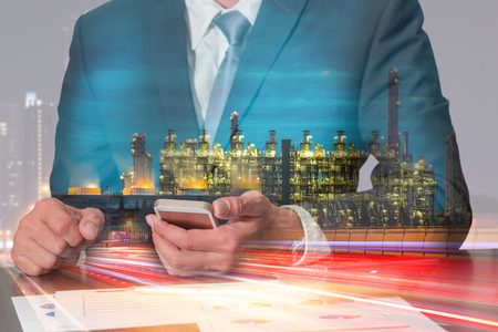 Double exposure of businessman working with smartphone, light trails on the street, Electric generating factory in the night as energy, business, commitment, technology and communication concept.の写真素材