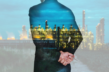 Double exposure of businessman think and analyze the work, electric generating factory industry in the twilight or night as energy, business, vision of leader concept.の写真素材