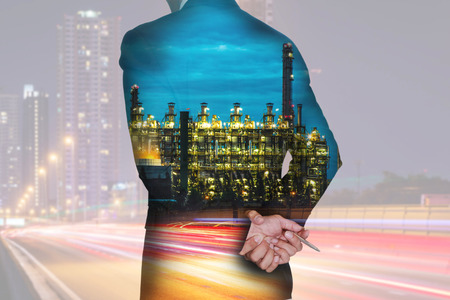 Double exposure of businessman think and analyze the work, light trails on the street and urban, Electric generating factory industry in the night as energy, business, vision of leader concept.の写真素材