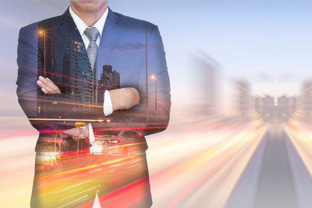 Double exposure of businessman arms crossed, light trails on the street and urban in the twilight on motion background as business and vision of leader concept.の写真素材