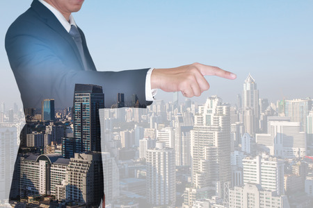 Double exposure of businessman finger point virtual target and cityscape in the morning as business and target concept.の写真素材