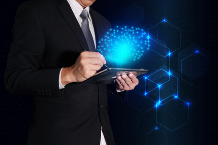 Businessman working with tablet and blue glowing brain as business, innovation, future, brainstorm, idea, control and technology concept.の写真素材