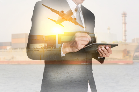 Double exposure of businessman working with tablet, Containers on the Cargo Ship and airplane flying as business, technology, industrial and transportation concept.の写真素材