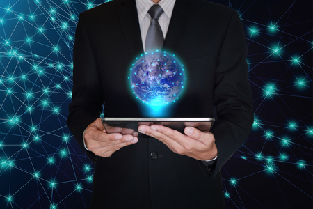 Double exposure of businessman hand hold tablet and light digital world on line glow network background as businessの写真素材