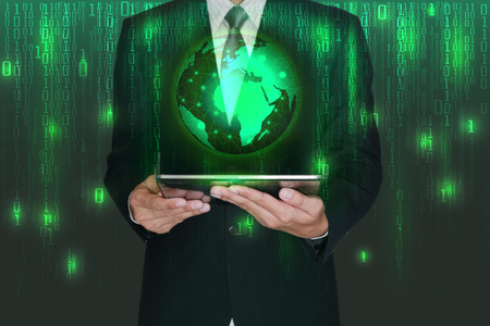 Double exposure of businessman hand hold tablet and virtual glowing light blue world on matrix digital background as business, technology, innovation and globalization conceptの写真素材