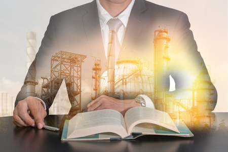 Double exposure of businessman sitting at meeting room to open the book, oil fuel, Electric generating factory, plant and sunset as business, meeting, Learning and industrial concept.の写真素材