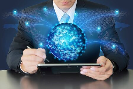 Double exposure of businessman working with tablet and glowing digital world map networking as businessの写真素材