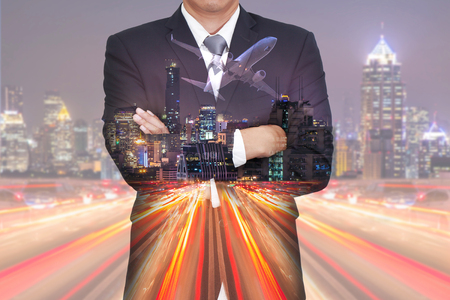 Double exposure of businessman arms crossed, airplane, light trails on the street, urban and city in the night as business and vision of leadership concept.の写真素材