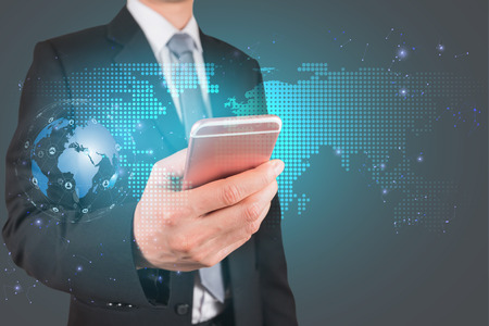 Double exposure of Businessman use smartphone and global networking and world map mesh as business, technology, communication and innovation concept.の写真素材
